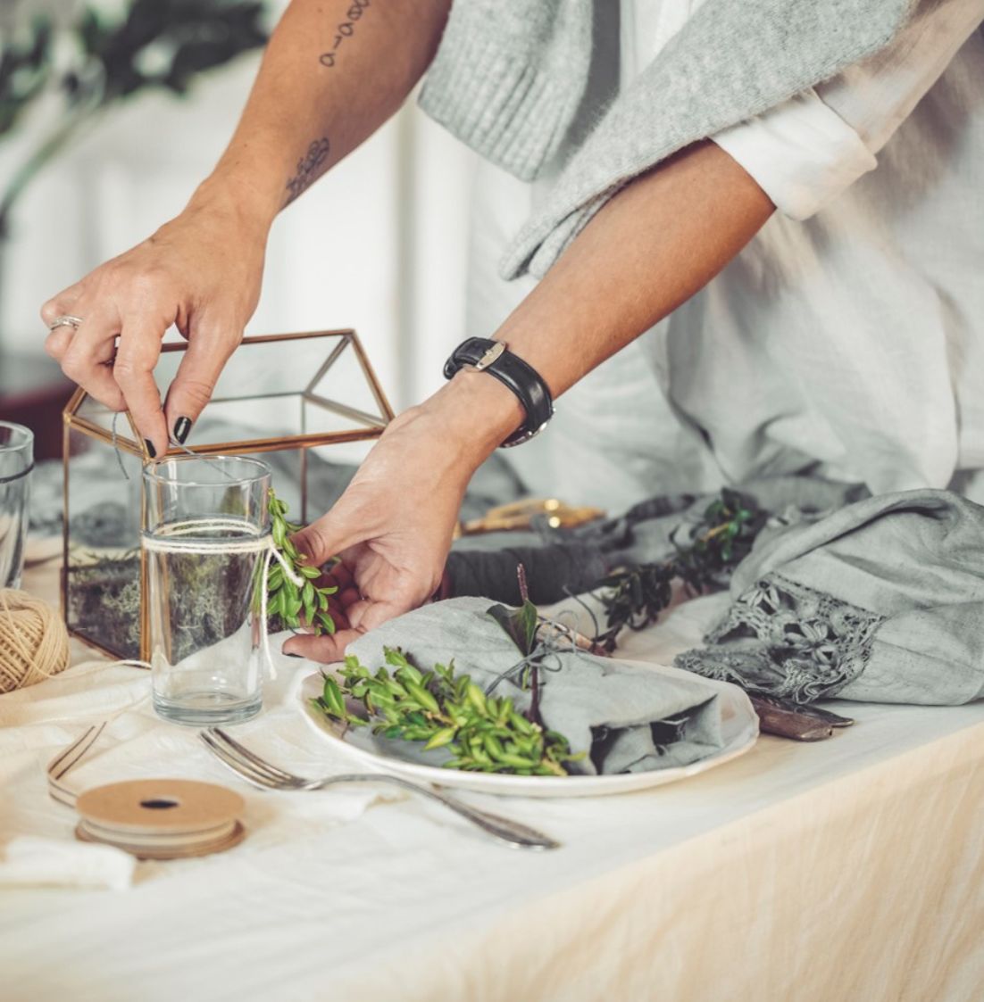 Hands arranging soil and plants in a glass container during DBD HUB’s Fittonia Terrarium Workshop, showing the layered structure of a miniature eco-garden with colorful Fittonia plants.