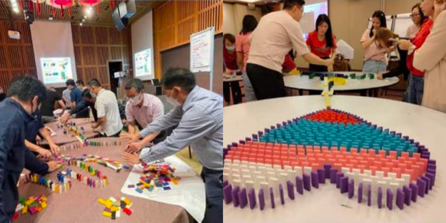 DBD HUB corporate wellness customised team building activity in Singapore featuring employees participating in a Domino Cause and Effect challenge to enhance teamwork, problem solving, and collaborative skills.