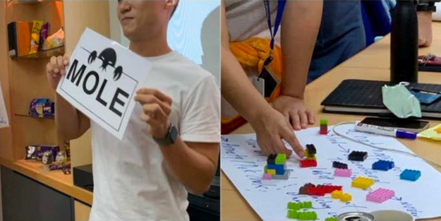 DBD HUB corporate wellness team building activity in Singapore showing employees participating in The Mole program—highlighting impact of gossip, assumptions, and workplace rumors on trust, team dynamics, and organizational harmony through experiential learning.